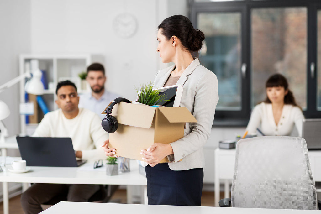 [UK] Fastest-paced job cuts in four years as wage growth stalls - woman let go from job belongings in box, UK job cuts