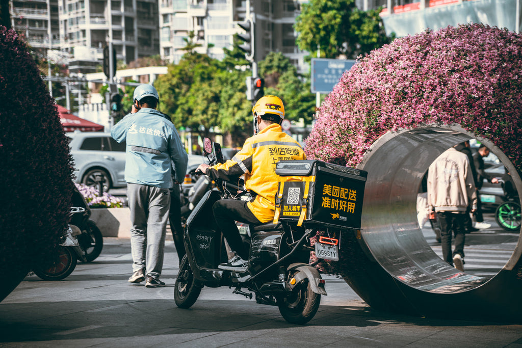 [China] Landmark gig worker labour rights rules drafted - delivery rider on a busy street in China